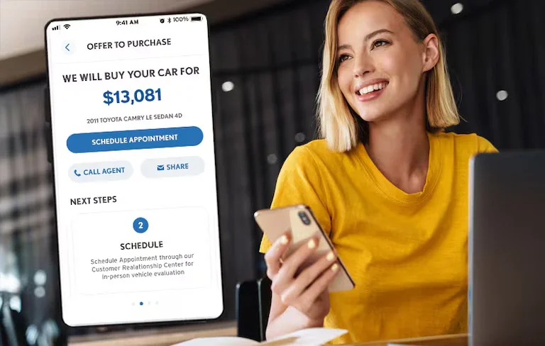 A mobile car-buying app displays an offer for a 2011 Toyota Camry, shown next to a smiling woman using a smartphone.